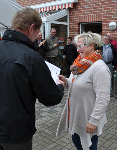 Die Nachbarschaftsvorsitzende Annette Wensing nimmt die Urkunde für den Brink entgegen.